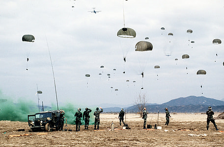 people stands on field near person riding on parachute at daytime thumbnail