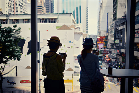 Two women looking through a window in Hong Kong, China thumbnail