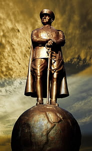 man standing on globe statue thumbnail