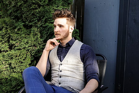 man wearing gray waistcoat sitting on chair thumbnail
