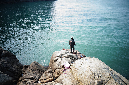 man standing on mountain infront of body of water during daytime thumbnail