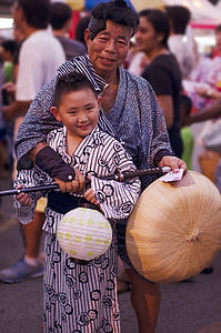 man holding hat and sword standing with boy during daytime thumbnail