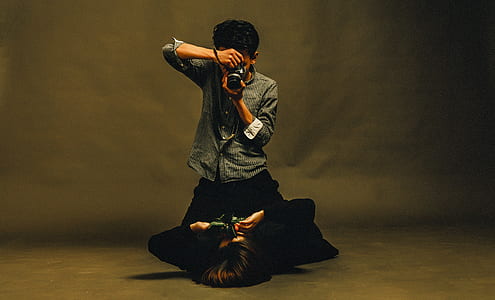 man taking picture of woman lying on floor thumbnail