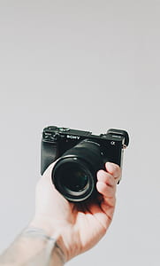 person hand holding Sony bridge camera thumbnail