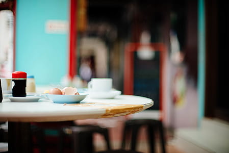 white ceramic plate near black bottle on table thumbnail