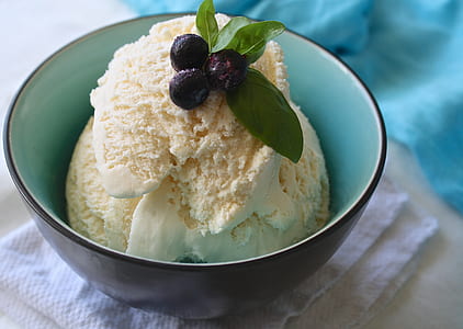 vanilla flavor ice cream with berry on top in black and teal ceramic bowl thumbnail