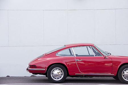 red coupe parked near white wall thumbnail