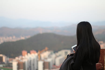 woman standing on terrace facing high rise buildings thumbnail