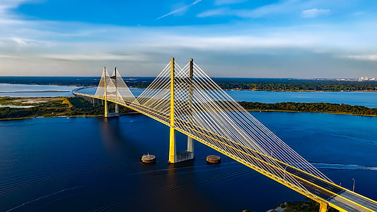 yellow steel bridge on body of water thumbnail