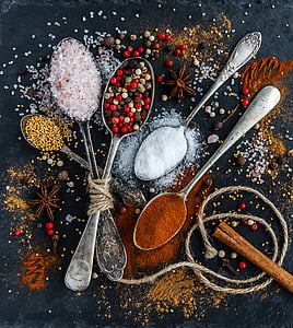 assorted condiments and toppings in stainless steel spoons thumbnail