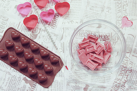 pink chocolate squares on bowl beside heart molding pan thumbnail
