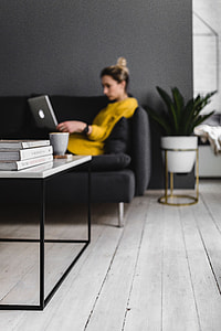Young woman sitting on the sofa and working on her laptop thumbnail