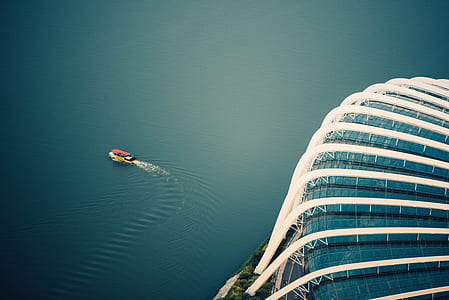 boat travelling away from glass building thumbnail