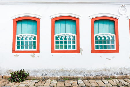 white painted house with red framed windows thumbnail