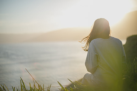 woman in white shirt facing sunset thumbnail