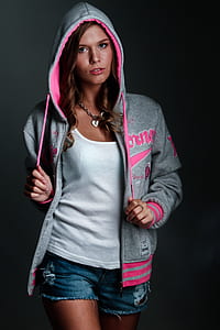 woman wearing pink and gray pullover hoodie, white shirt, and blue short shorts thumbnail