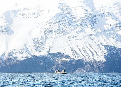 ship sailing on body of water beside icy mountain thumbnail