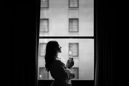 Woman In Hotel Room Window With Coffee Photo thumbnail