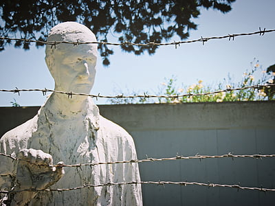 man statue holding barbwire at daytime thumbnail