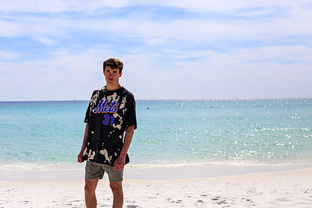 man in gray short standing on shore under sunny sky thumbnail