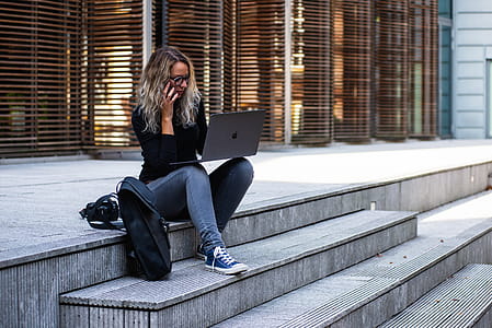 Woman Sitting on Stairs While Using Laptop thumbnail