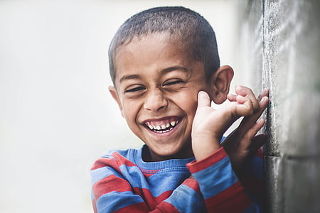 boy smiling leaning on wall thumbnail