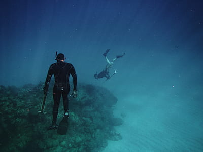 two scuba divers holding spearguns thumbnail
