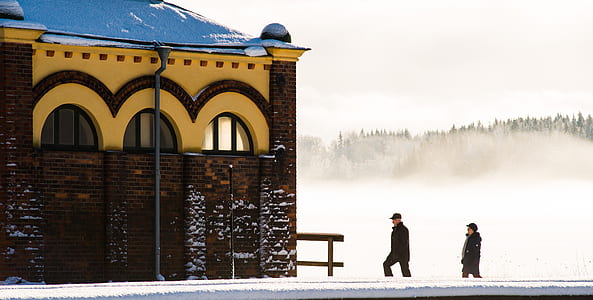 two people walking near building background of trees thumbnail