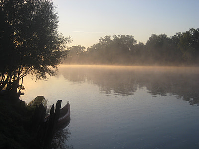 silhouette photo of forest and body of water during daytime thumbnail