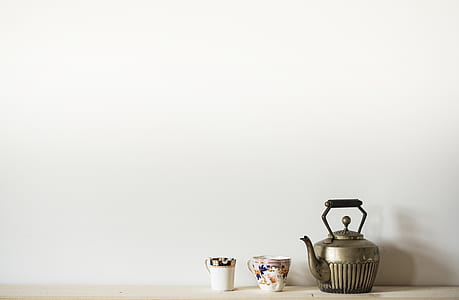 silver teapot beside white ceramic mug on floor thumbnail