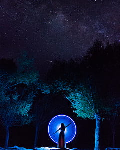 woman between tree during nighttime thumbnail
