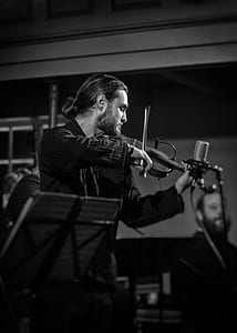 grayscale photo of man playing violin indoor thumbnail
