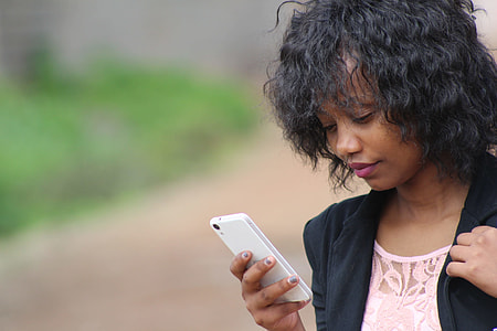 selective focus photography of woman holding white android smartphone thumbnail