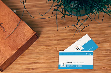 two white-and-blue cards on brown wooden surface thumbnail