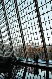two silhouette of persons walking near glass wall inside building architectural photography thumbnail
