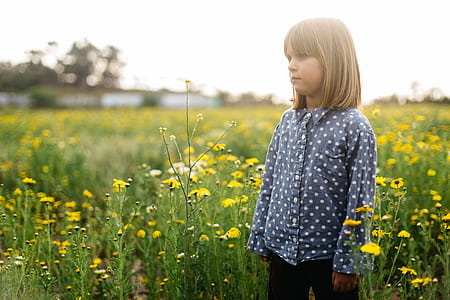 girl standing in yellow flower field thumbnail
