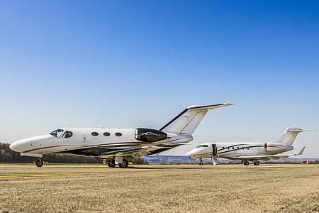 two white airplanes on grassland during daytime thumbnail