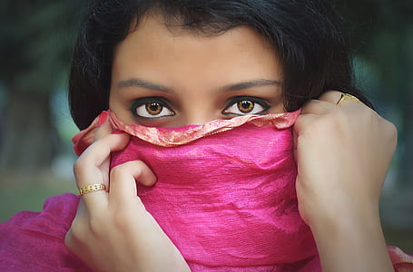 woman covering her half face with pink textile at daytime thumbnail