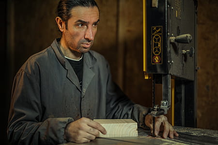 Man in Gray Dress Shirt Operating Band Saw thumbnail