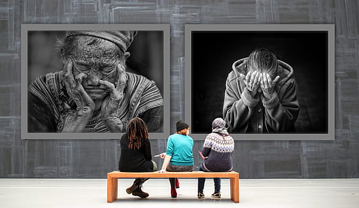 three women on brown wooden bench in front of painting thumbnail