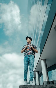 man in blue denim pants standing on concrete floors looking on right thumbnail