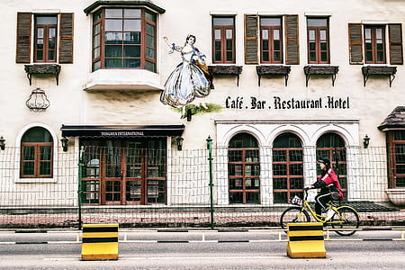 girl wearing red shirt riding bicycle near building during daytime thumbnail