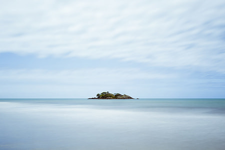 island under cloudy sky during daytime thumbnail