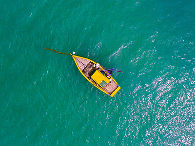 bird's eyeview photo of yellow boat on body of water thumbnail