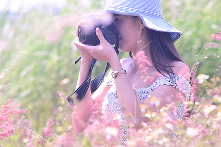 woman holding black DSLR camera thumbnail