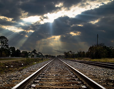 photo of train rail under crepuscular rays background thumbnail