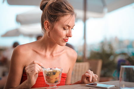 Woman Holding Silverware While Looking at Phone thumbnail