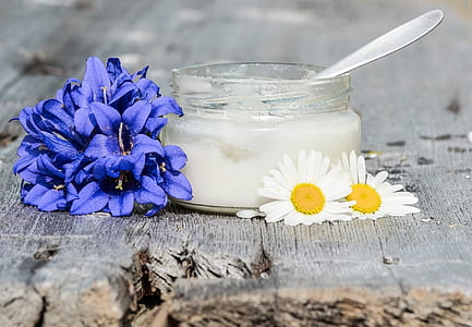 two purple and white petaled flowers beside glass container thumbnail
