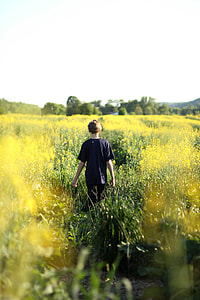 boy walking on the middle of grass field thumbnail