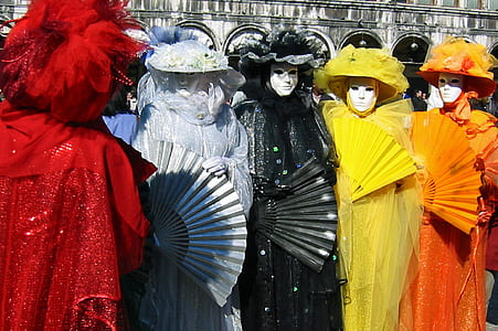 four person dressed and assorted-color dresses with full face mask standing beside each other thumbnail
